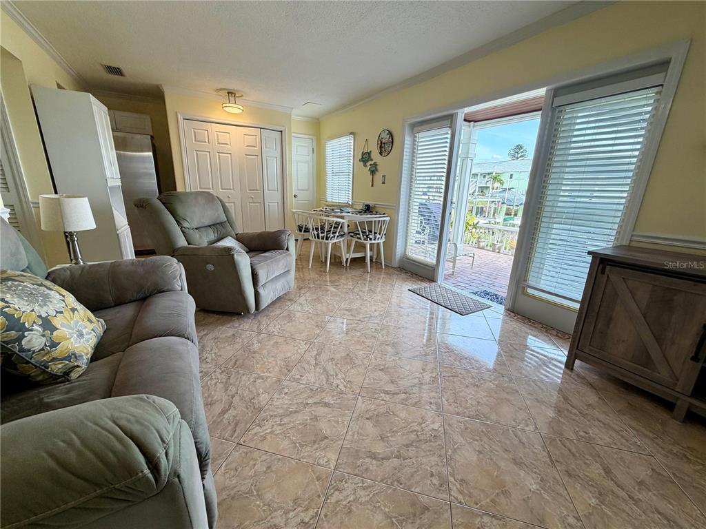 A living and dining area features tile floors, a sliding glass door, and patio access — 5009 STARFISH DRIVE SE UNIT A, ST PETERSBURG, FL