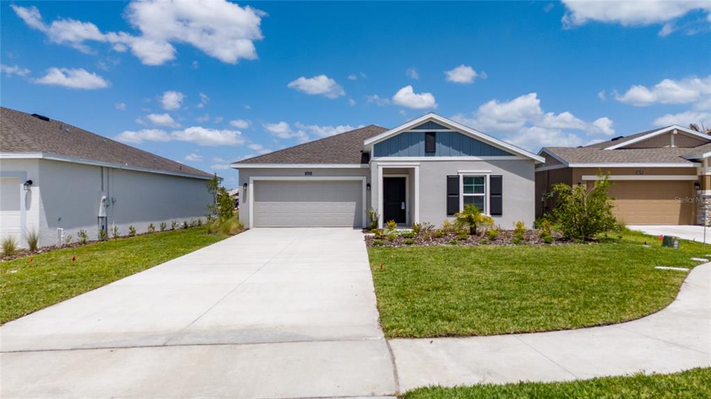 A single-story suburban house features a gray stucco exterior, a two-car garage, and blue siding — 5625 LE MARIN WAY, KISSIMMEE, FL