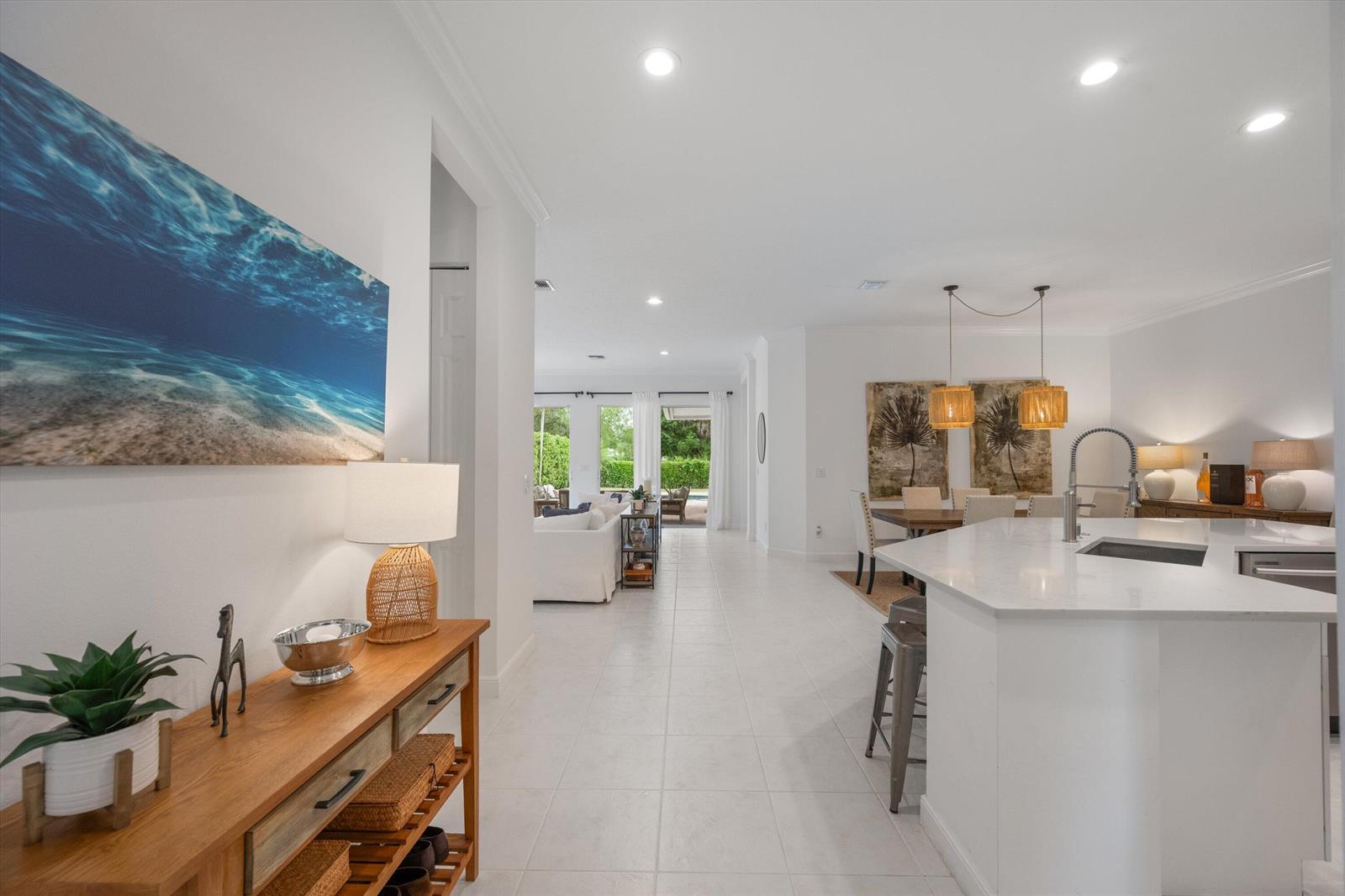 A bright, open-concept home interior features a kitchen island, dining area, and living room — 2920 Twin Oaks Way, Wellington FL 33414, WELLINGTON, FL