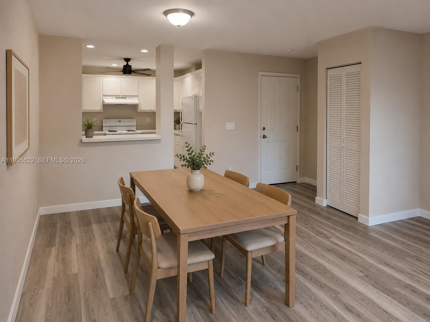 A dining area with a wooden table and chairs sits adjacent to an open kitchen — 3655 NW 94th Ave # 8H, Sunrise FL 33351, SUNRISE, FL