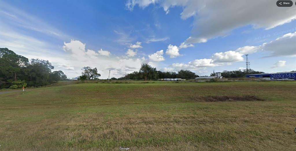 A wide, grassy, undeveloped lot under a blue sky with scattered clouds — N/A, POLK CITY, FL