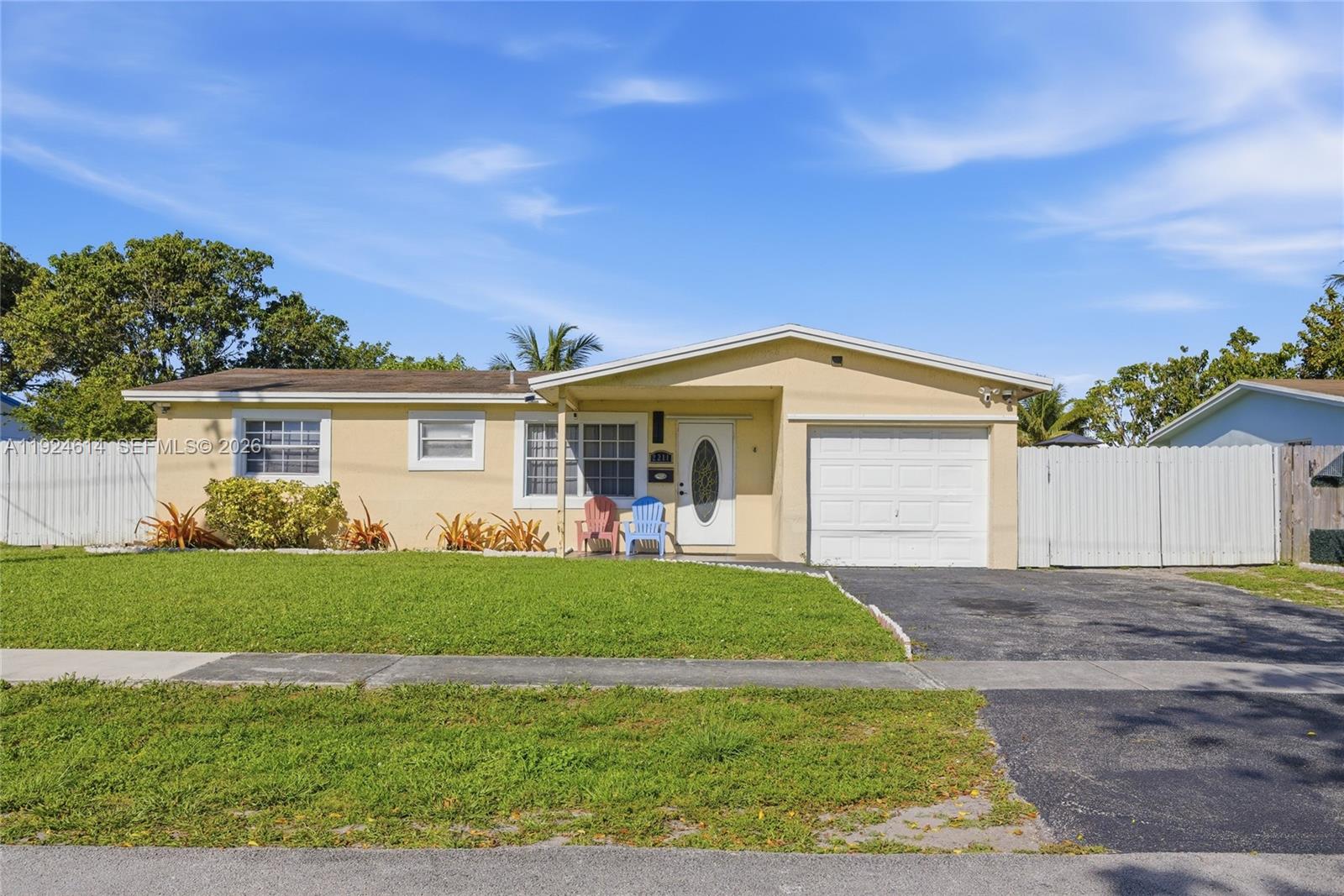 A single-story yellow house features a white garage door, a front porch, and a lawn — 2211 NW 46th Ave, Lauderhill FL 33313, LAUDERHILL, FL
