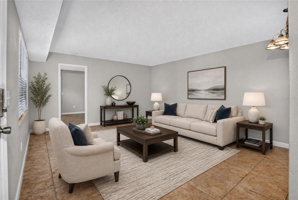 A living room features a beige sofa, matching armchair, coffee table, and tile flooring — 53 WINDTREE LANE UNIT 102, WINTER GARDEN, FL