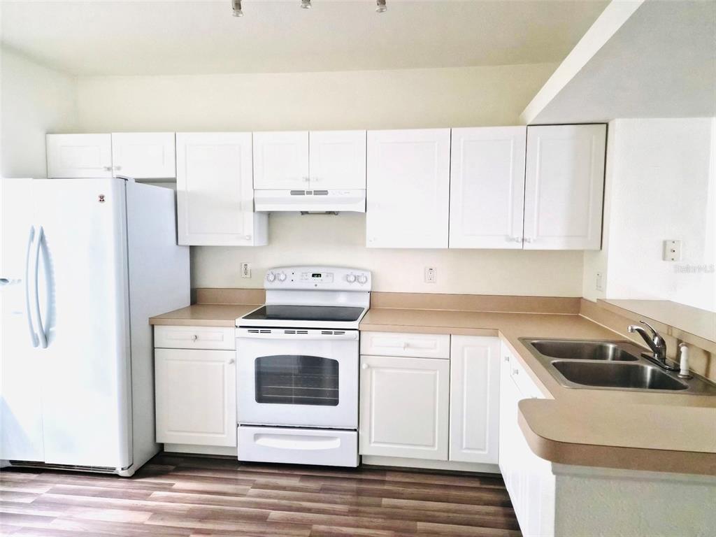 A kitchen features white cabinets, a white refrigerator, a white stove, and tan countertops — 4352 HAR PAUL CIRCLE, TAMPA, FL