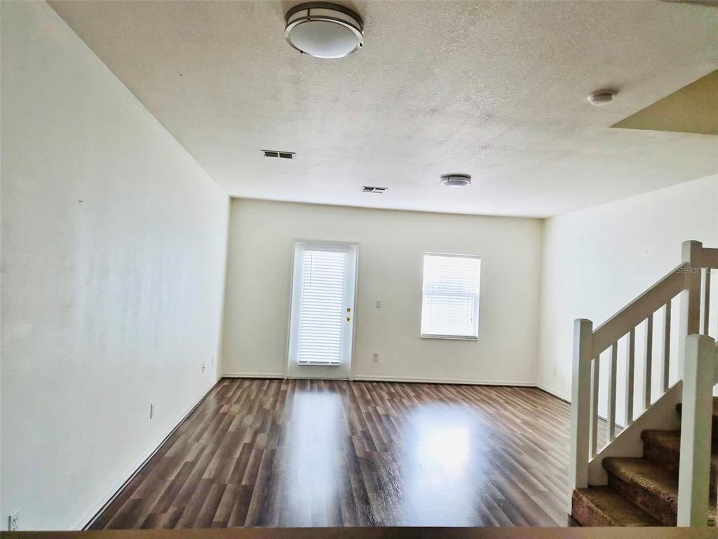 An interior view of a living area featuring wood-look flooring and a staircase — 4352 HAR PAUL CIRCLE, TAMPA, FL