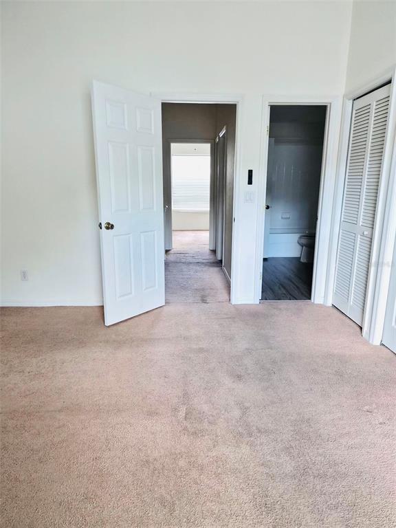 A carpeted bedroom features an open door to a hallway and a bathroom entrance — 4352 HAR PAUL CIRCLE, TAMPA, FL