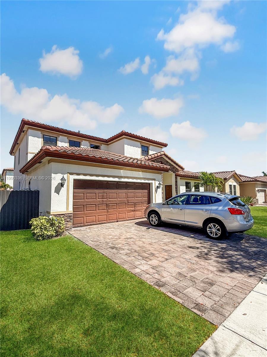 A two-story stucco house with a tile roof and a two-car garage — 709 SE 35th Ave, Homestead FL 33033, HOMESTEAD, FL