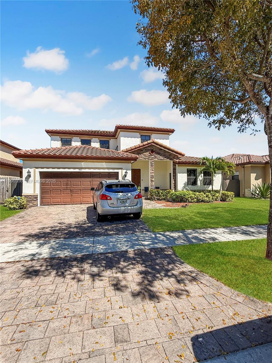 A two-story suburban house with a tiled roof, a paved driveway, and a parked car — 709 SE 35th Ave, Homestead FL 33033, HOMESTEAD, FL