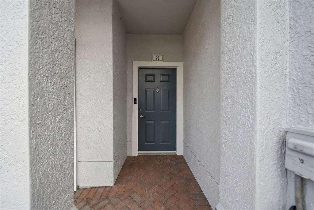 A dark blue front door with the number eight above it sits in a recessed entryway — 2532 GRAND CENTRAL PARKWAY UNIT 8, ORLANDO, FL