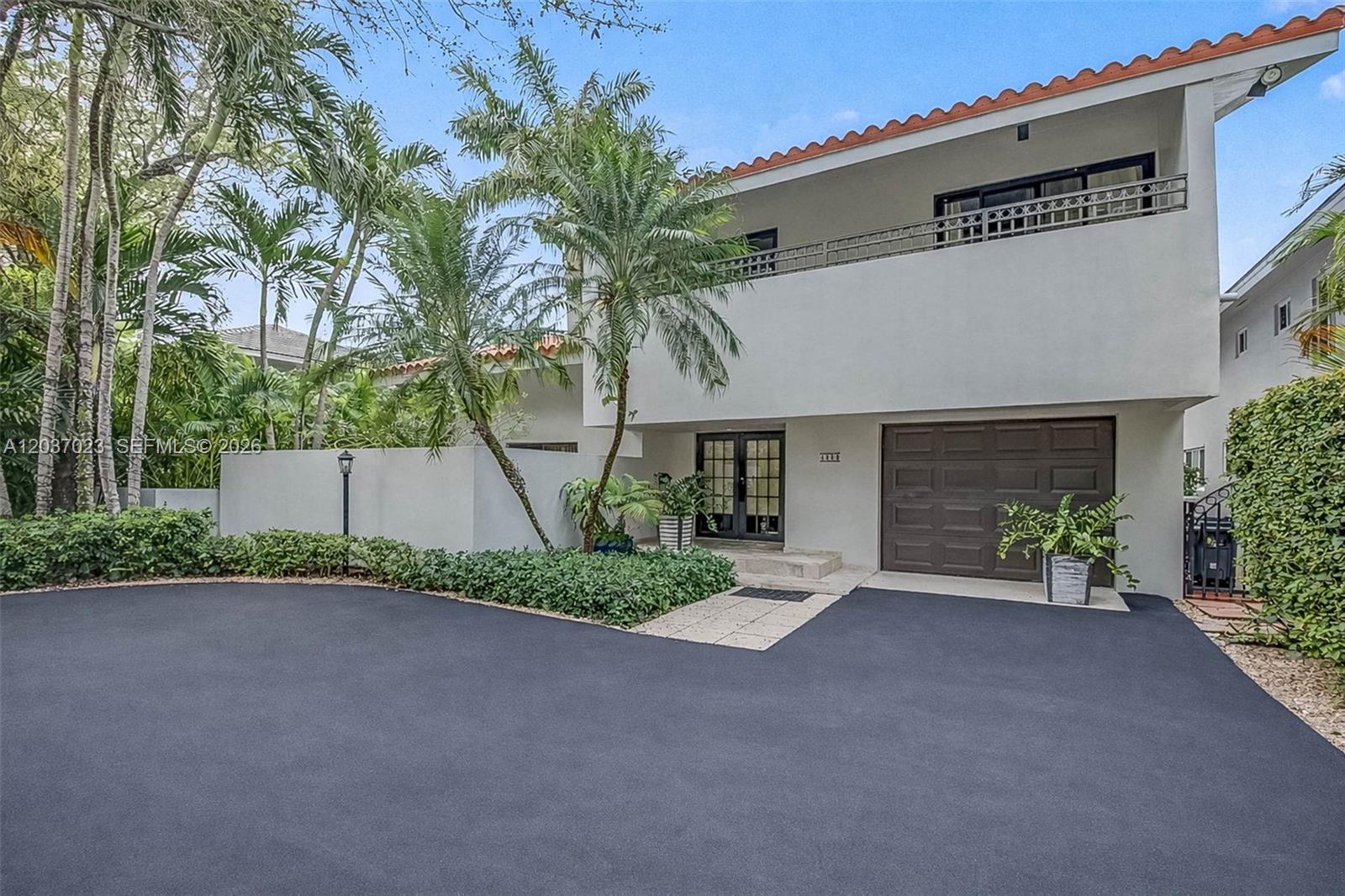 A two-story house with a brown garage door, a balcony, and a paved driveway — 4950 San Amaro Dr, Coral Gables FL 33146, CORAL GABLES, FL