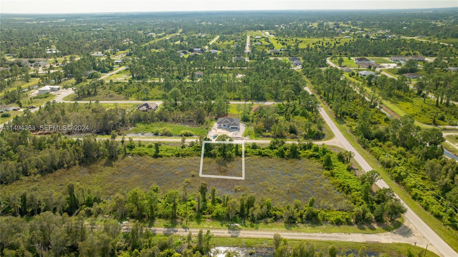 An aerial view shows a rectangular plot of land outlined in white within a rural area — 853 Belden Ave, Lehigh Acres FL 33936, LEHIGH ACRES, FL