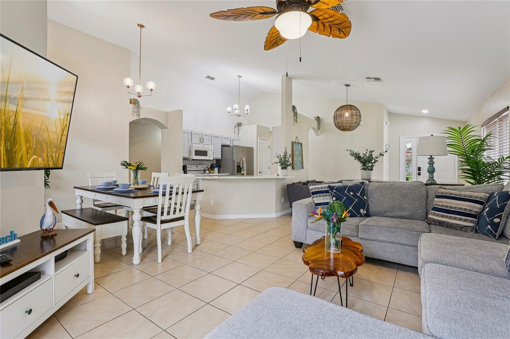 An open-concept living and dining area features tile flooring, a ceiling fan, and kitchen access — 136 ROSSO DRIVE, DAVENPORT, FL