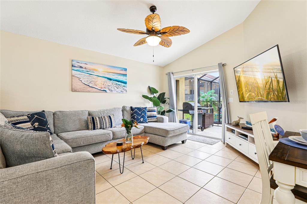 A living room features a gray sectional sofa, a live-edge coffee table, and a ceiling fan — 136 ROSSO DRIVE, DAVENPORT, FL