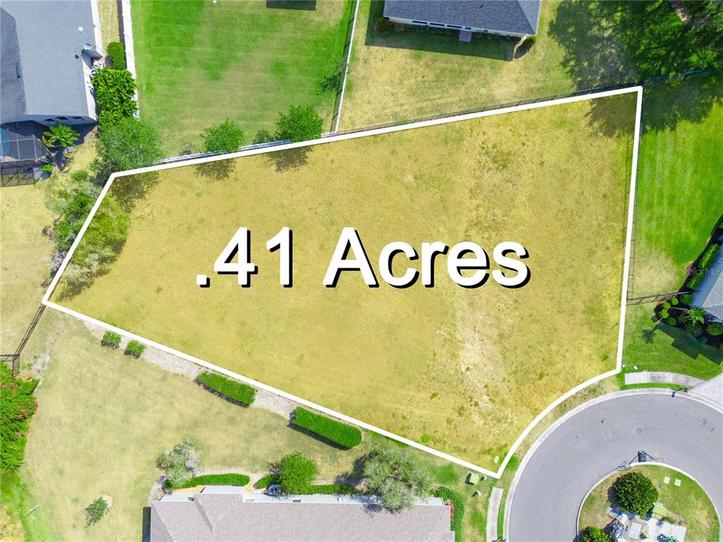 An aerial view shows a vacant, fenced residential lot measuring .41 acres — WHISPER WOODS DRIVE, LAKELAND, FL
