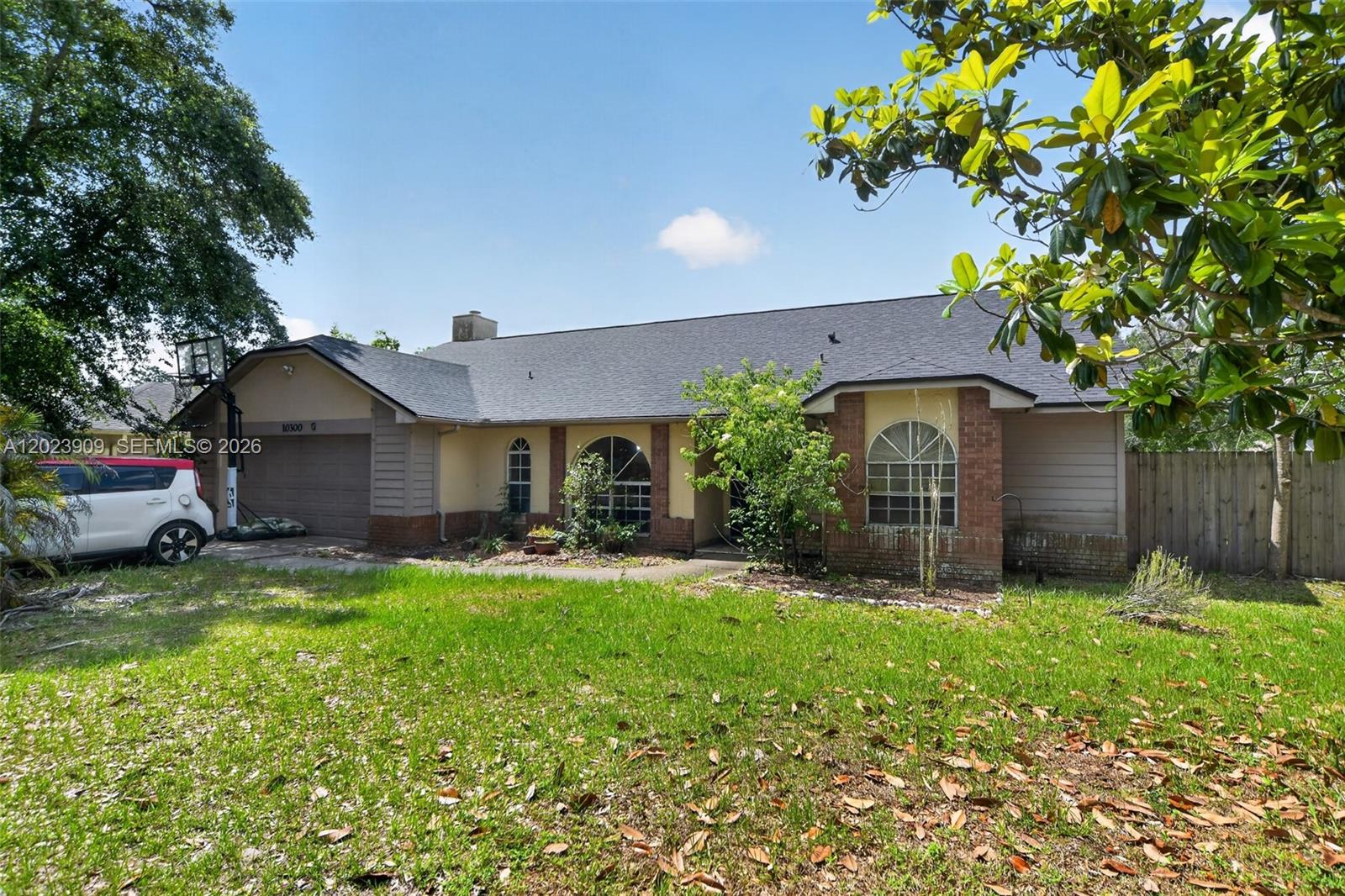 A single-story house with a brick and siding exterior, a garage, and a front lawn — 10300 YORKMERE CT, Orlando FL 32817, ORLANDO, FL