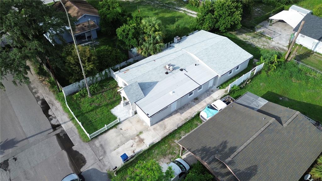An aerial view shows a single-story house with a white roof and a concrete driveway — 5103 N 30TH STREET, TAMPA, FL