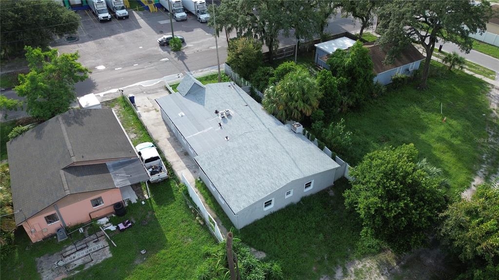 An aerial view shows two adjacent houses with gray roofs and surrounding green lawns — 5103 N 30TH STREET, TAMPA, FL