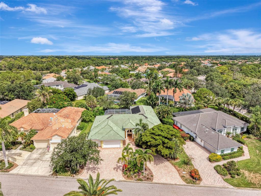 An aerial view of a suburban house with a green roof and a paved driveway — 4708 SWEETMEADOW CIRCLE, SARASOTA, FL