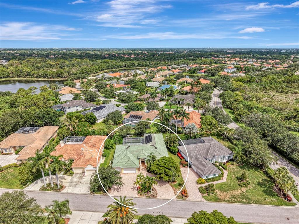 An aerial view shows a single-story house with a green roof and a screened pool — 4708 SWEETMEADOW CIRCLE, SARASOTA, FL