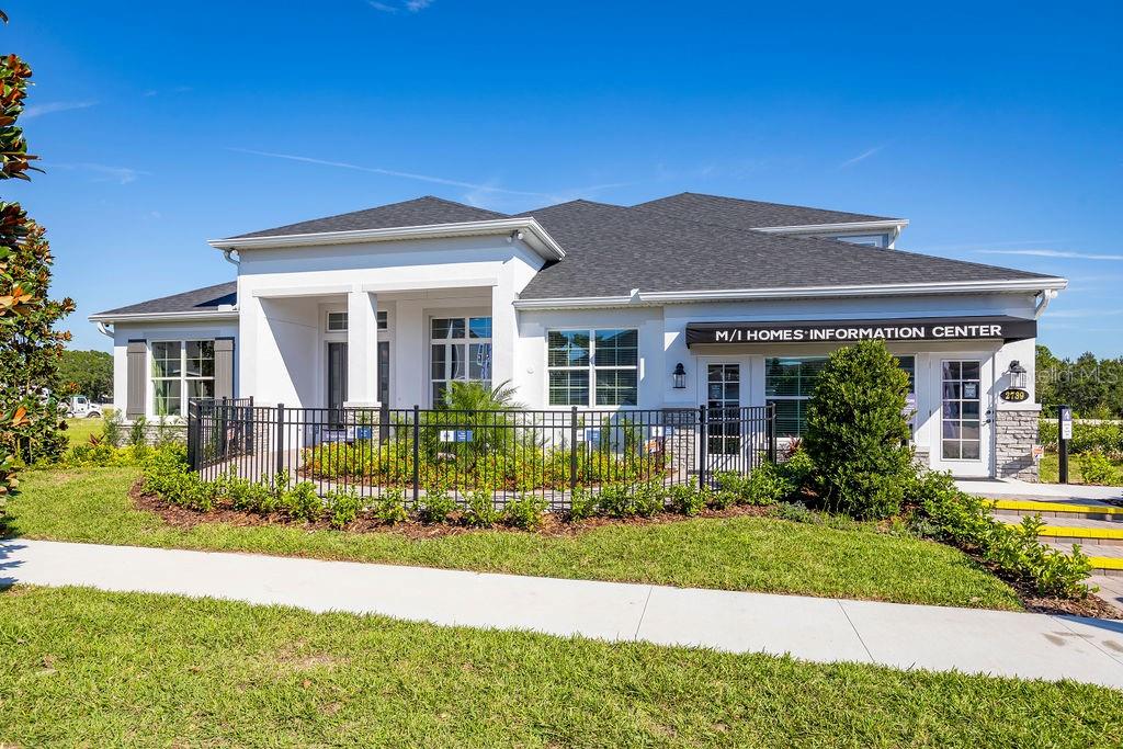 A white, single-story building with a dark roof serves as an M/I Homes information center — 2739 RAVENCLIFFE TERRACE, OVIEDO, FL