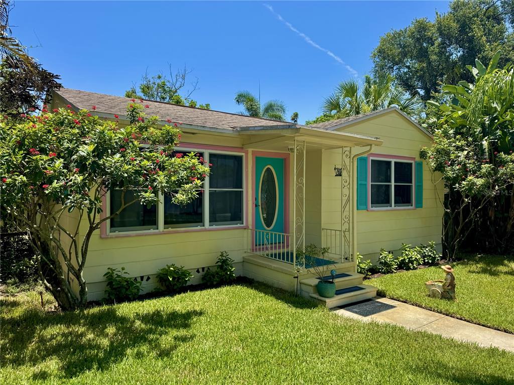 A yellow single-story house with a turquoise front door and a small front porch — 2602 UPTON STREET S, GULFPORT, FL