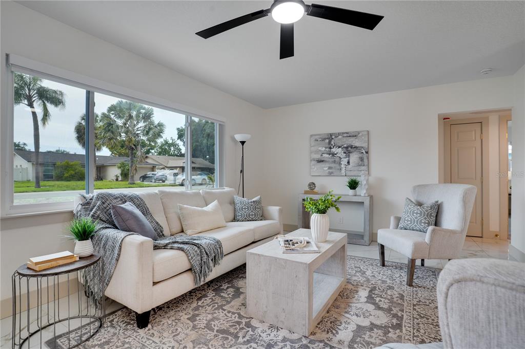 A living room features a white sofa, a coffee table, and a large window view — 12425 RIDGE ROAD, LARGO, FL
