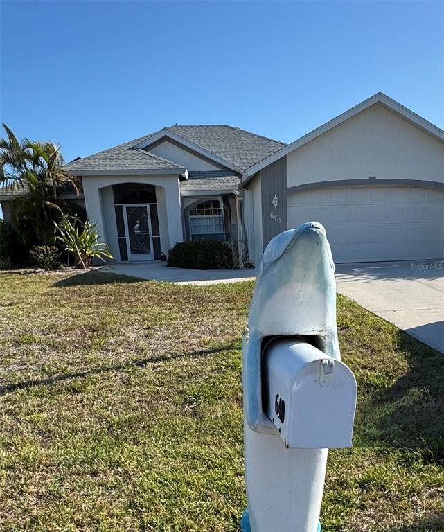 A single-story house with a garage and a dolphin-shaped mailbox in the front yard — 640 BOUNDARY BOULEVARD, ROTONDA WEST, FL