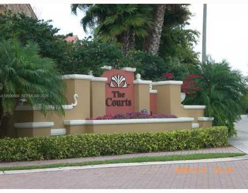 A tan stucco monument sign for The Courts stands behind a manicured hedge — 6630 NW 114th AV # 1503, Doral FL 33178, DORAL, FL