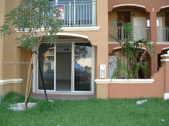A ground-level apartment patio features sliding glass doors, a small tree, and a grassy lawn — 6630 NW 114th AV # 1503, Doral FL 33178, DORAL, FL