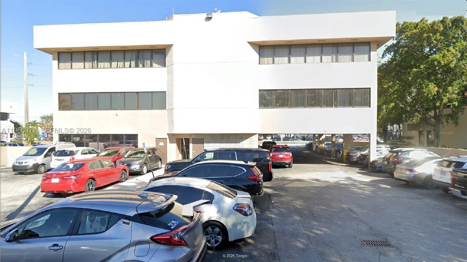 A three-story white commercial building with a ground-level parking area and several parked cars — 8080 W Flagler St, Miami FL 33144, MIAMI, FL