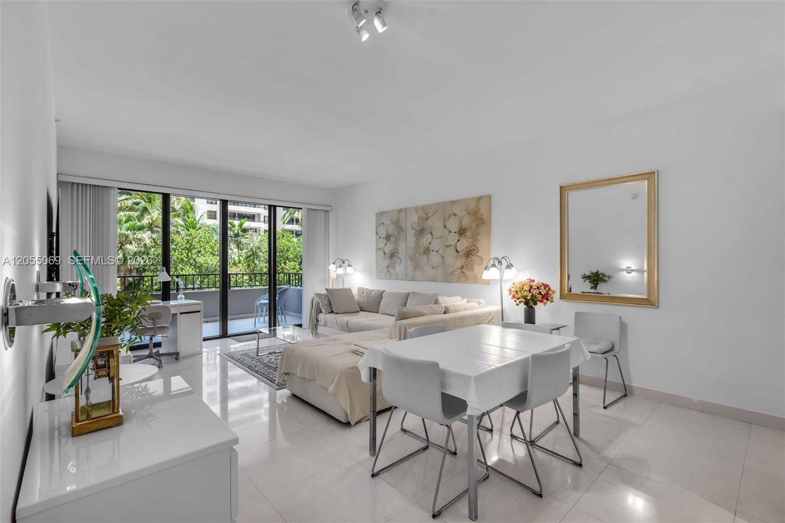 A bright living and dining area features white tile floors, a sectional sofa, and balcony access — 201 Crandon Blvd # 220, Key Biscayne FL 33149, KEY BISCAYNE, FL