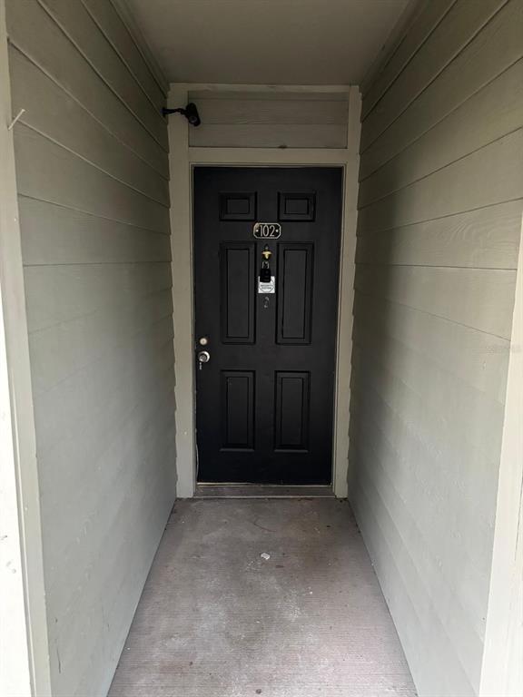 A black front door with a lockbox is situated in a recessed entryway — 6028 WESTGATE DRIVE UNIT 102, ORLANDO, FL