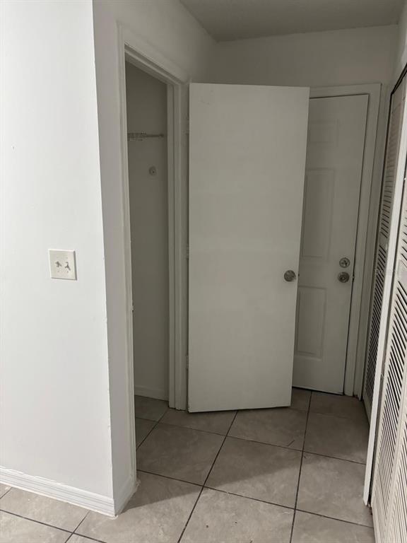 A hallway features tiled floors, a closet, and two white interior doors — 6028 WESTGATE DRIVE UNIT 102, ORLANDO, FL
