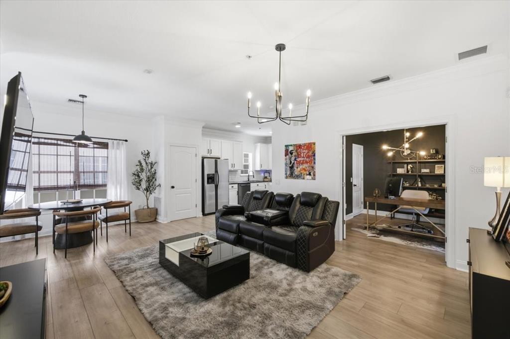 A living room with a black leather sofa, dining area, and an adjacent home office — 2315 W NORTH A STREET UNIT 3, TAMPA, FL