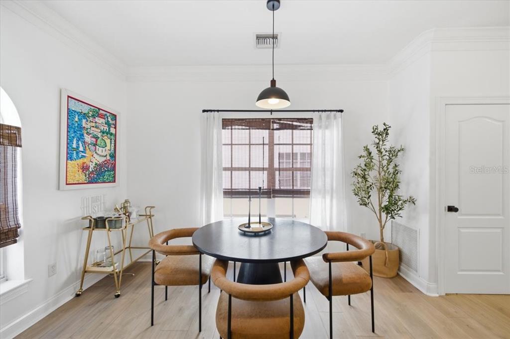 A dining room features a round black table, tan chairs, and a gold bar cart — 2315 W NORTH A STREET UNIT 3, TAMPA, FL