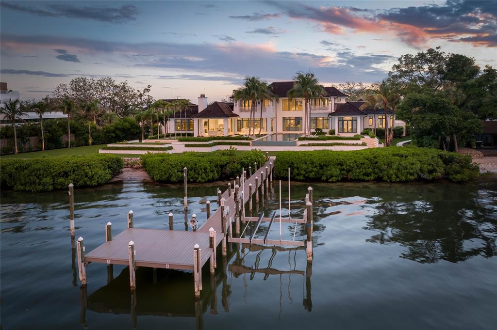 A large waterfront estate with a private dock, swimming pool, and landscaped lawn at sunset — 8501 MIDNIGHT PASS ROAD, SARASOTA, FL