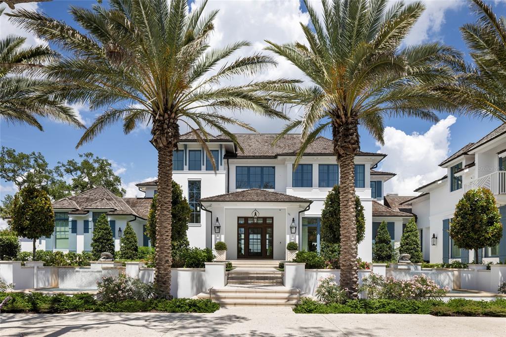 A two-story white luxury home with a shingled roof, palm trees, and a stone entryway — 8501 MIDNIGHT PASS ROAD, SARASOTA, FL
