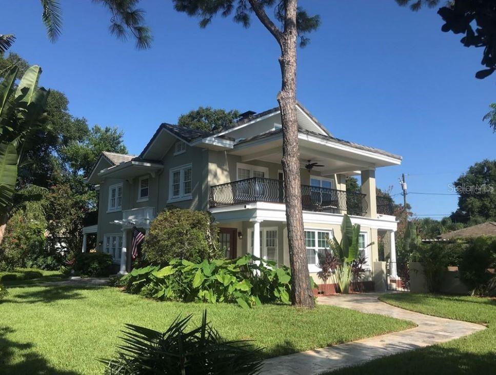 A two-story house with a wrap-around porch, balcony, and a large tree in the yard — 209 13TH AVENUE N, ST PETERSBURG, FL