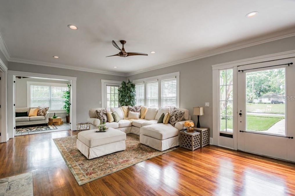 A living room features a large sectional sofa, hardwood floors, and a ceiling fan — 209 13TH AVENUE N, ST PETERSBURG, FL