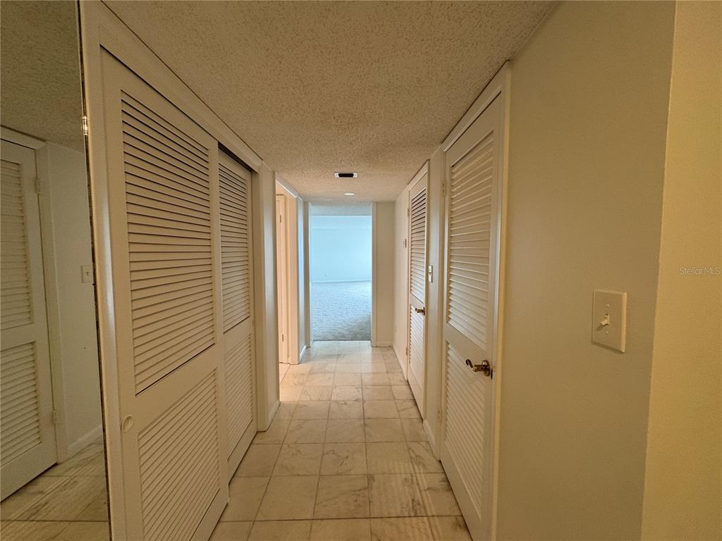 A hallway with tiled floors and louvered closet doors leads to an open room — 2611 BAYSHORE BOULEVARD UNIT 1805, TAMPA, FL