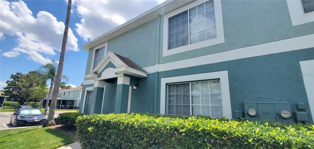 A two-story teal apartment building with a covered entryway and a hedge in front — 1661 FLUORSHIRE DRIVE, BRANDON, FL