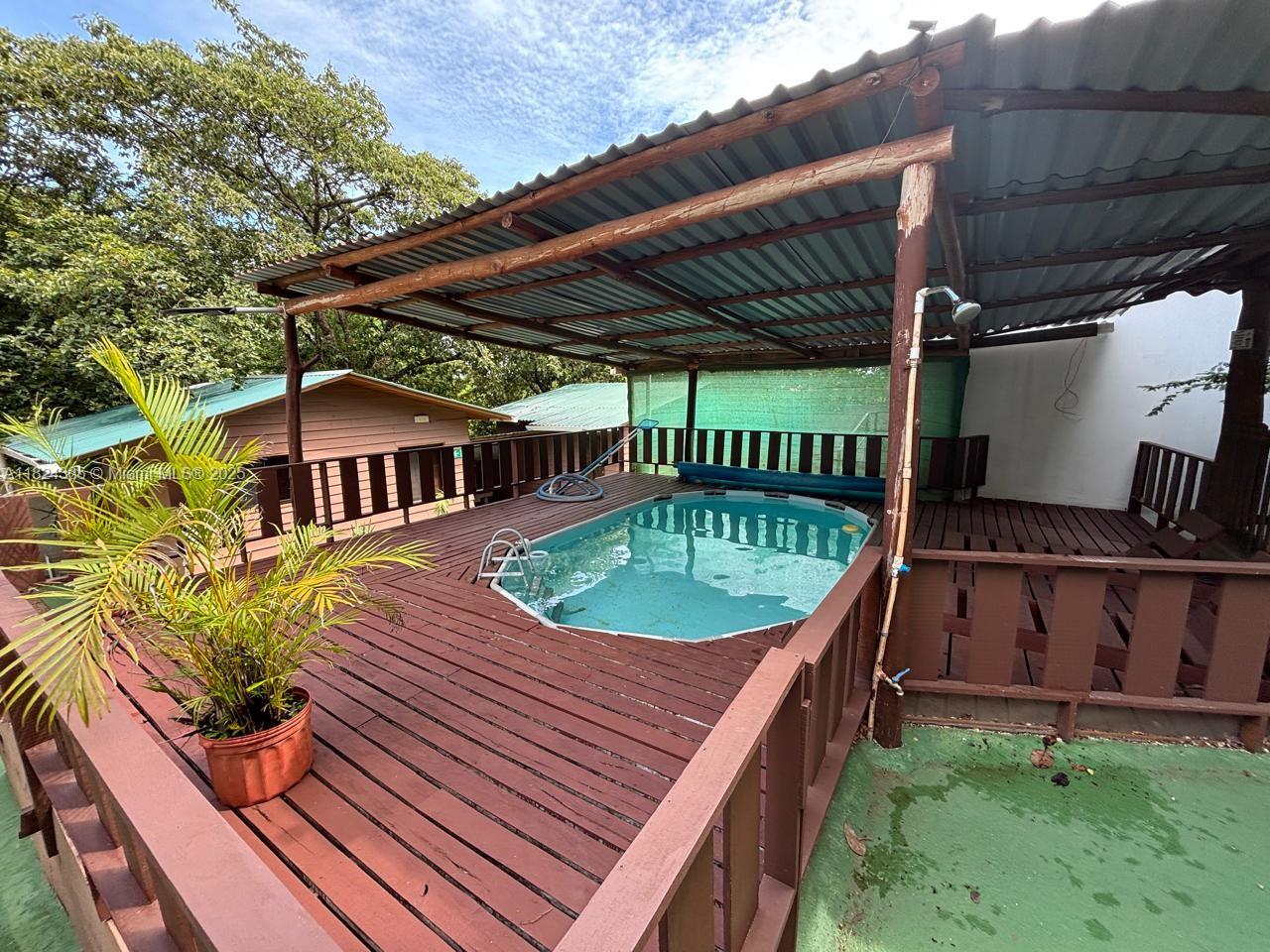 An elevated wooden deck features a small swimming pool under a covered roof structure — 27 de Abril Playa Junquillal, IA 50303, IA
