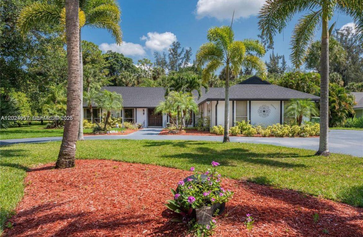 A single-story house with a dark shingled roof and a circular driveway surrounded by palms — 13353 Doubletree Cir, Wellington FL 33414, WELLINGTON, FL