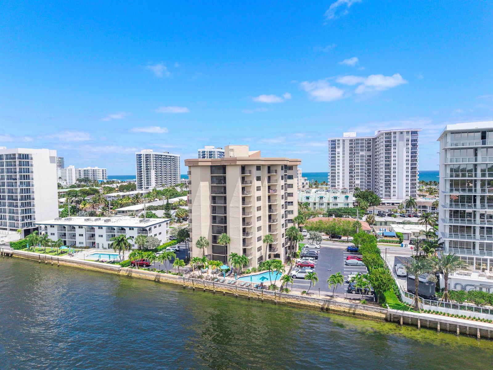 An aerial view shows waterfront apartment buildings with swimming pools and parking lots — 501 N Riverside Drive # 203, Pompano Beach FL 33062, POMPANO BEACH, FL