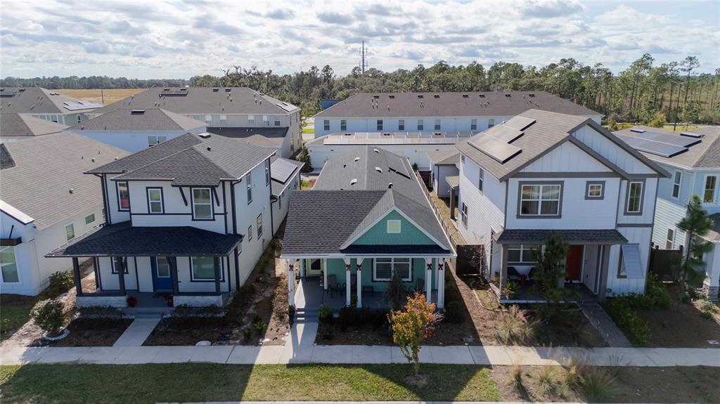 An aerial view shows three suburban houses with dark shingled roofs and front porches — 6430 ROVER WAY, ST CLOUD, FL