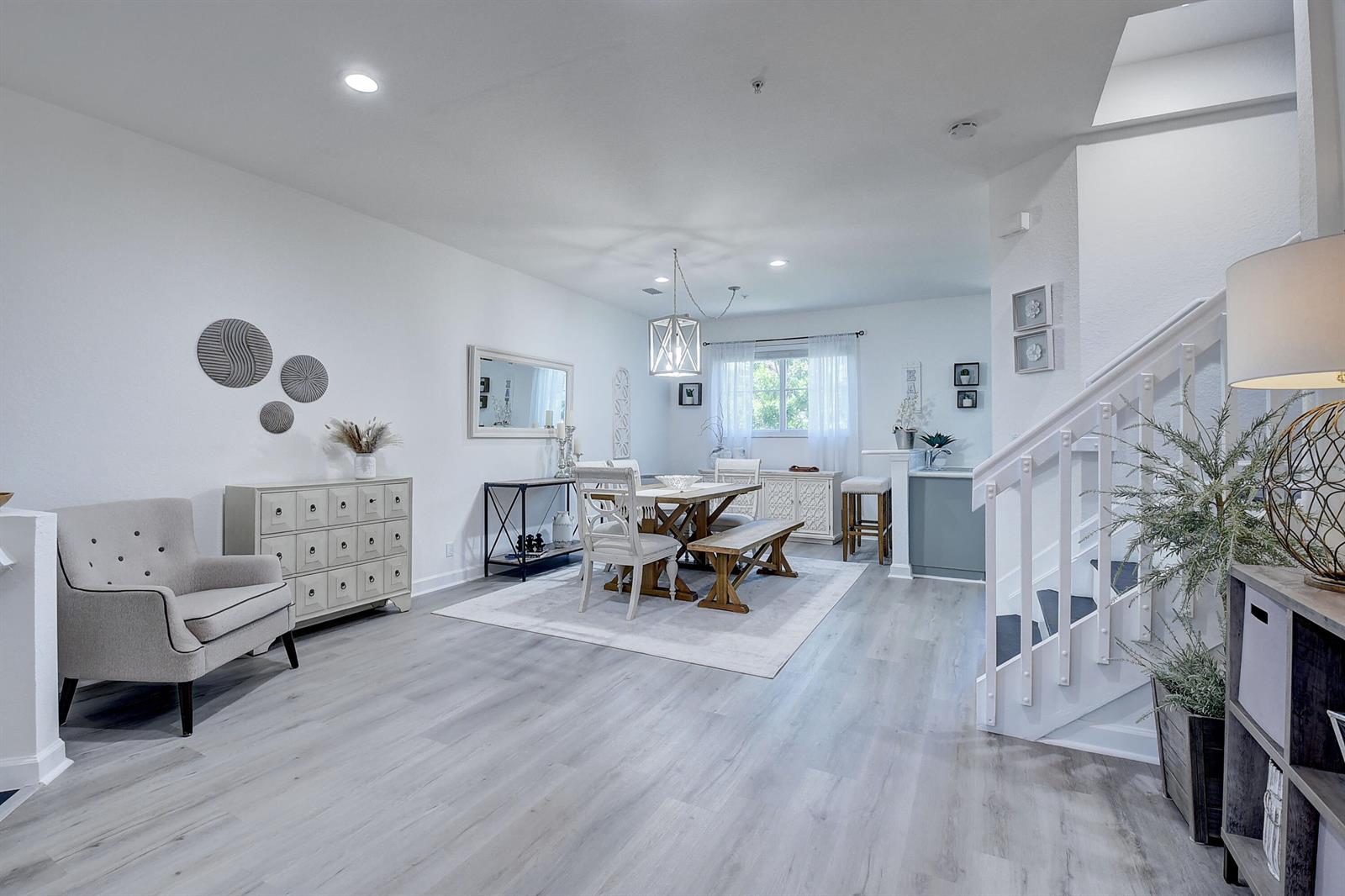 A dining area with a wooden table and bench sits next to a staircase and armchair — 525 Bayfront Drive, Boynton Beach FL 33435, BOYNTON BEACH, FL