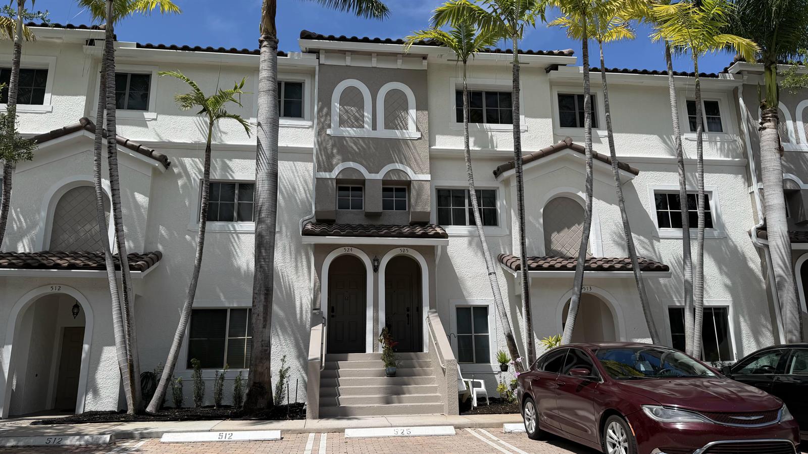 A multi-story residential building with stucco walls, arched entryways, and palm trees in front — 525 Bayfront Drive, Boynton Beach FL 33435, BOYNTON BEACH, FL