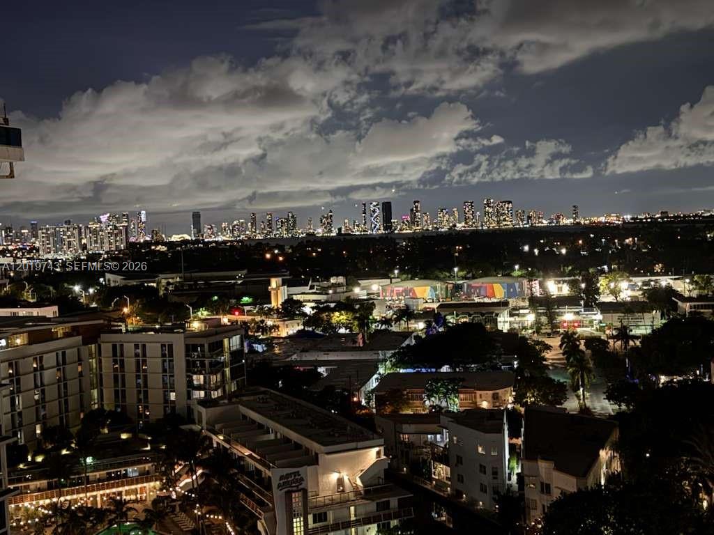 An elevated night view of a city skyline featuring illuminated buildings and a cloudy sky — 2401 Collins Ave # 1807, Miami Beach FL 33140, MIAMI BEACH, FL