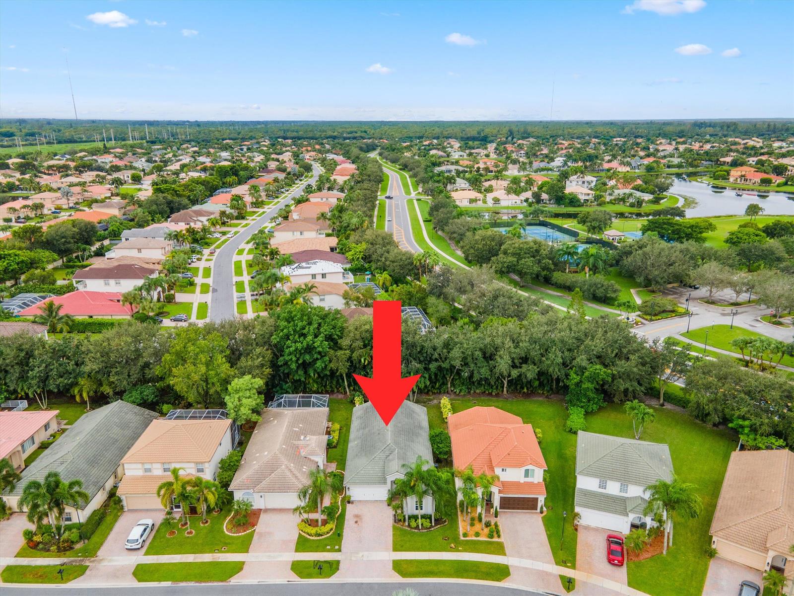 An aerial view shows a single-family home with a gray roof and a red arrow — 4221 Bluff Harbor Way, Wellington FL 33449, WELLINGTON, FL