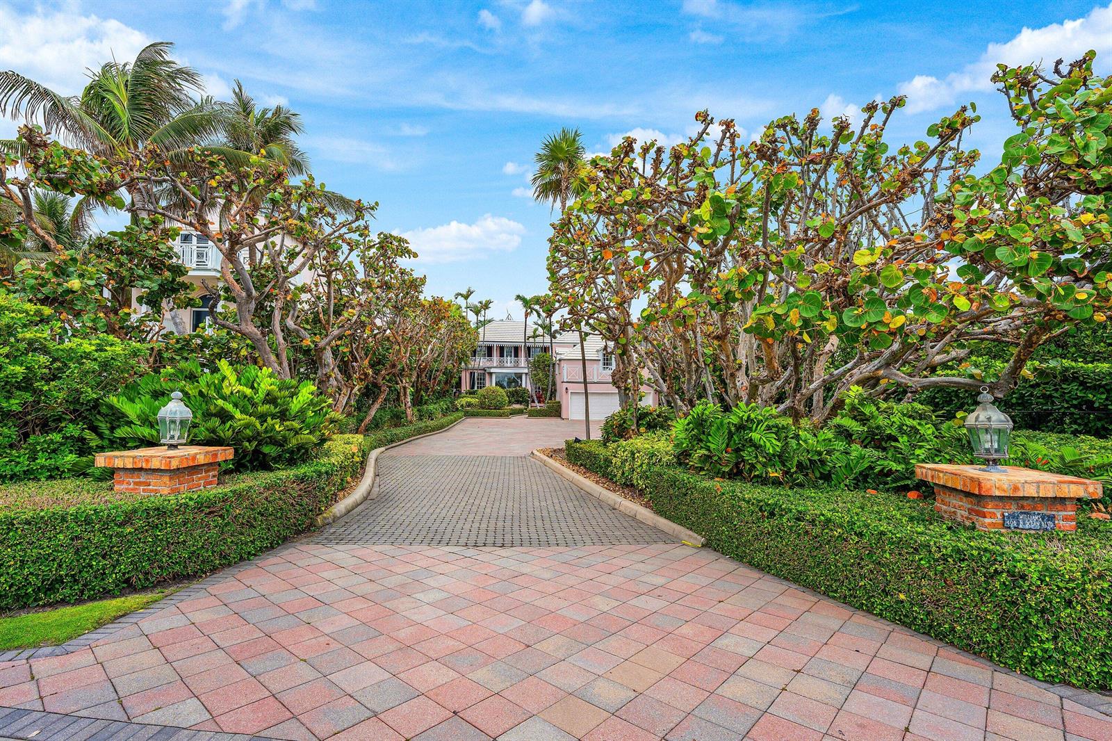 A paved driveway leads toward a house framed by lush trees and manicured hedges — 406 N Ocean Boulevard, Delray Beach FL 33483, DELRAY BEACH, FL